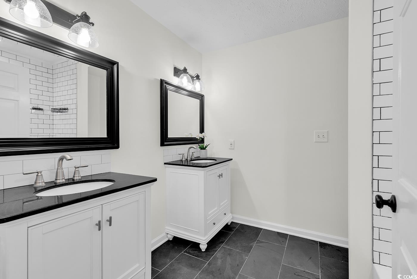 506 Merrywood Drive Conway, SC 29526 - Photo 22 of 40 Bathroom featuring two vanities, backsplash, dark tile patterned flooring, and a shower