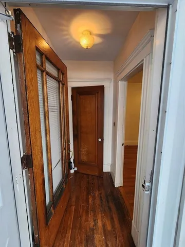 a view of a hallway with wooden floor and stairs