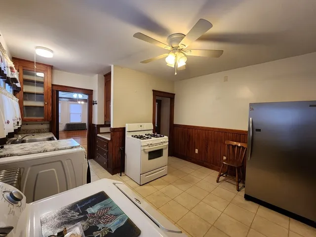 a kitchen with a stove a refrigerator and a dining table