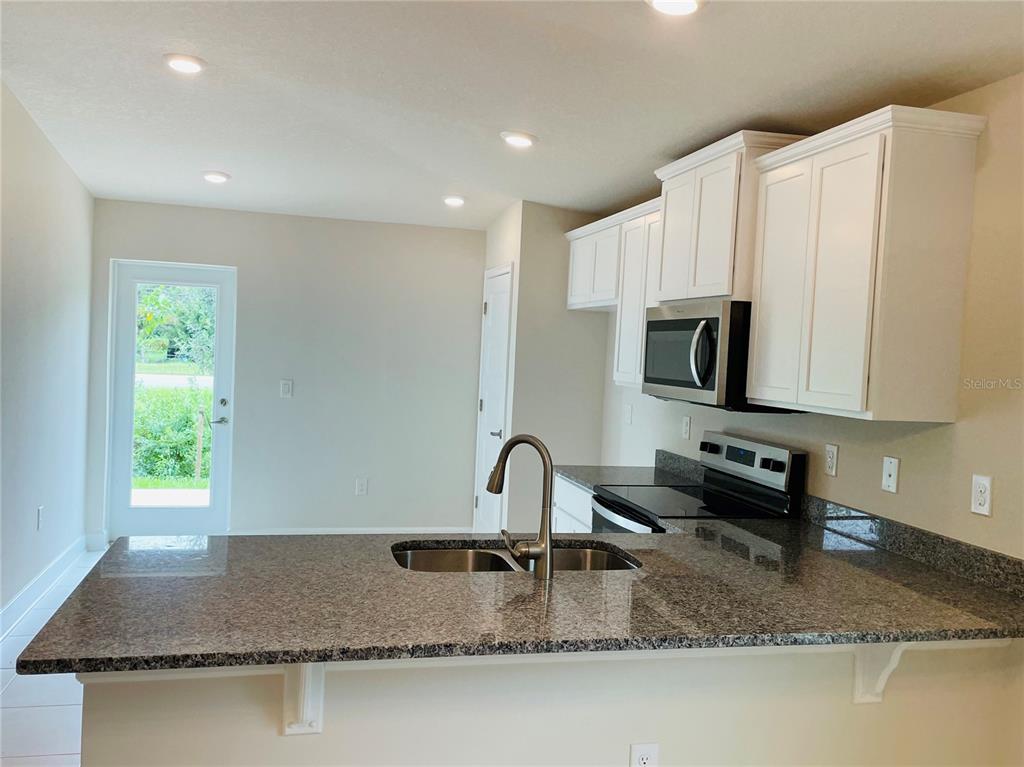 7625 Bent Tree Loop St. Cloud, FL 34773 - Photo 3 of 8 a kitchen with sink a window and a counter top space