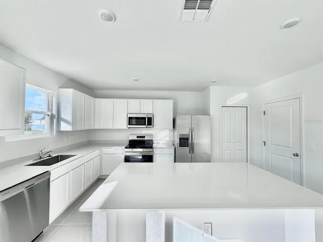 a large kitchen with cabinets and stainless steel appliances
