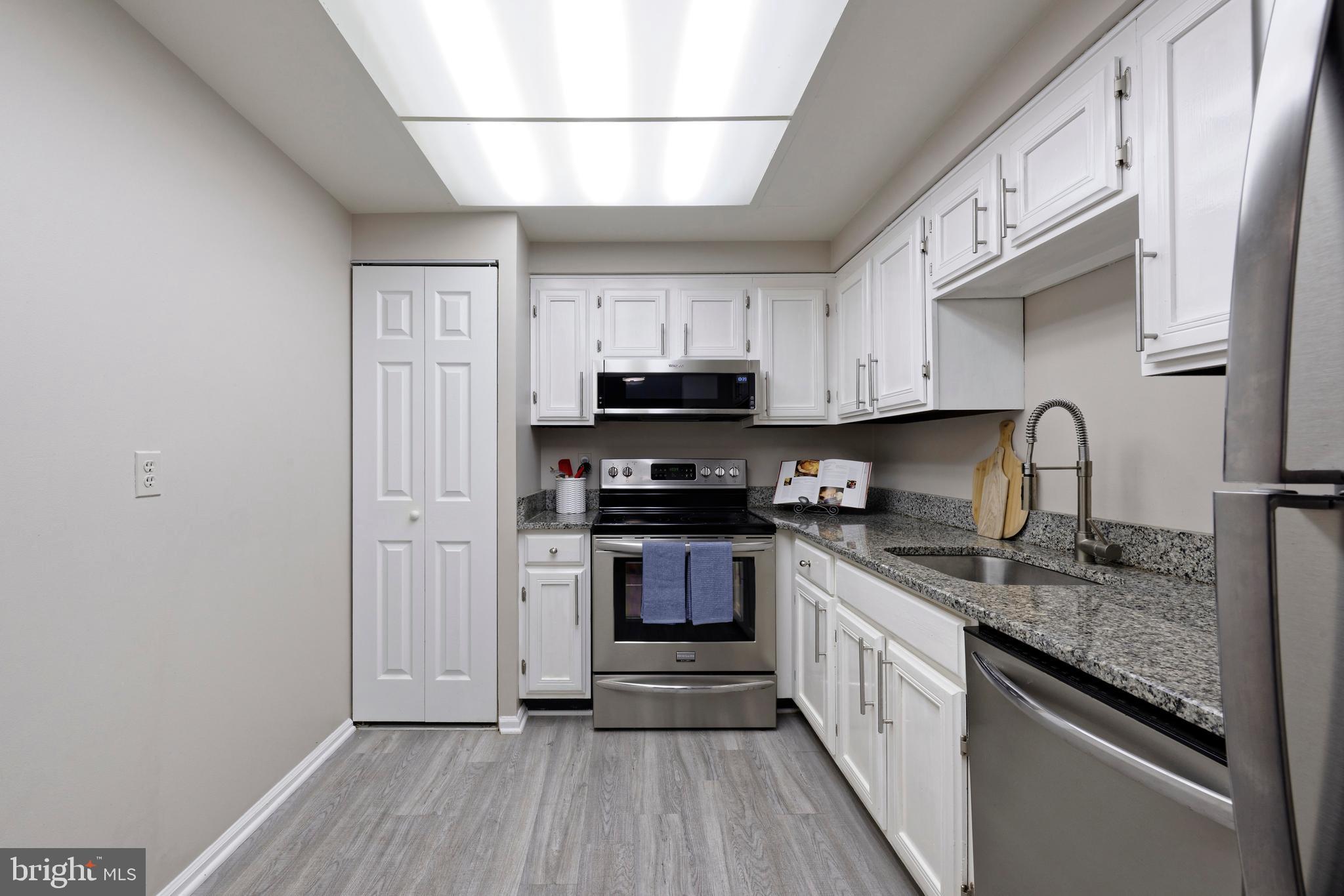 7680 Tremayne Place, Unit 308 McLean, VA 22102 - Photo 7 of 31 a kitchen with stainless steel appliances granite countertop a stove and a sink