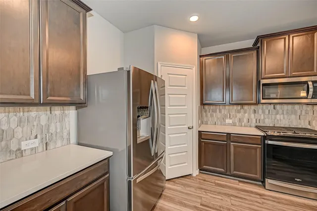 a kitchen with stainless steel appliances and wooden cabinets
