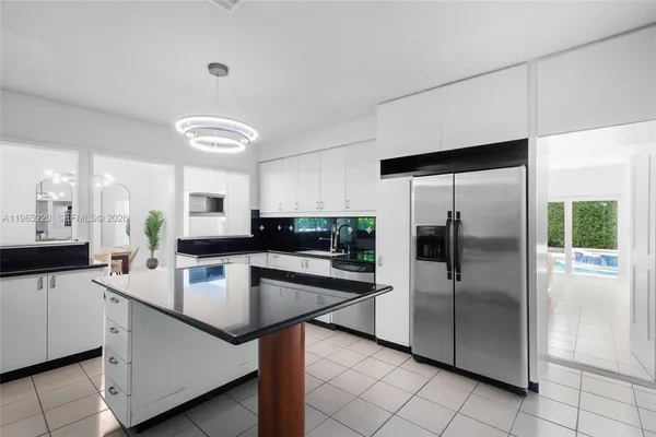 a kitchen with kitchen island a counter top space cabinets and stainless steel appliances
