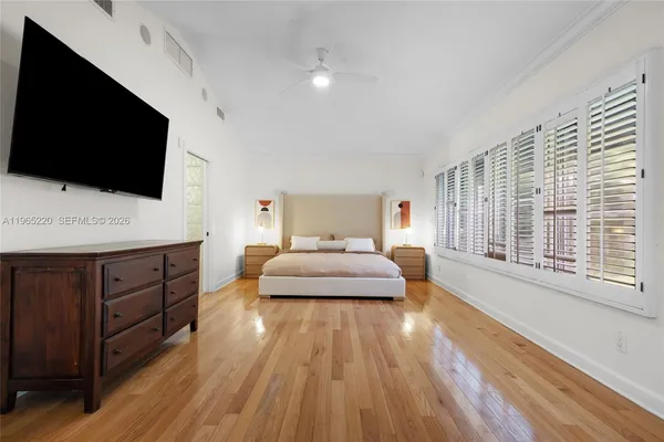 a spacious bedroom with a bed and a flat screen tv