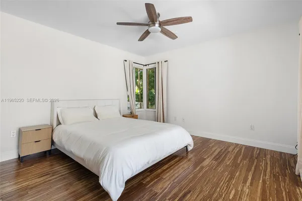 a bedroom with a bed and a ceiling fan