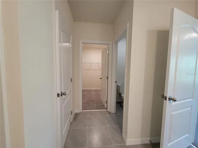 a view of a bathroom from the hallway with a glass door