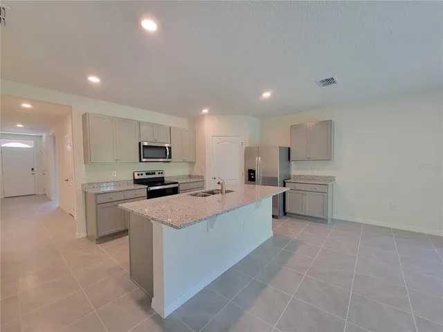 a large white kitchen with cabinets and stainless steel appliances