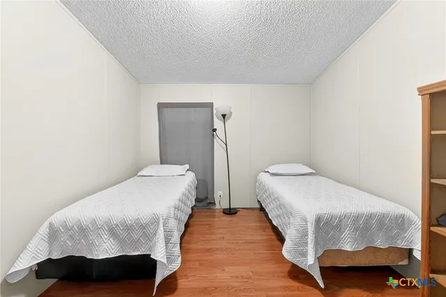 a bedroom with a bed and wooden floor