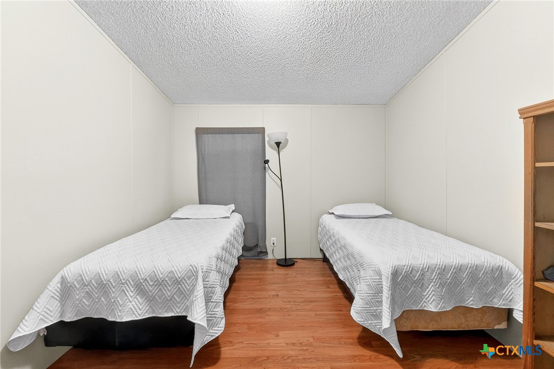 11213 Ridgewood Drive Salado, TX 76571 - Photo 17 of 24 a bedroom with a bed and wooden floor