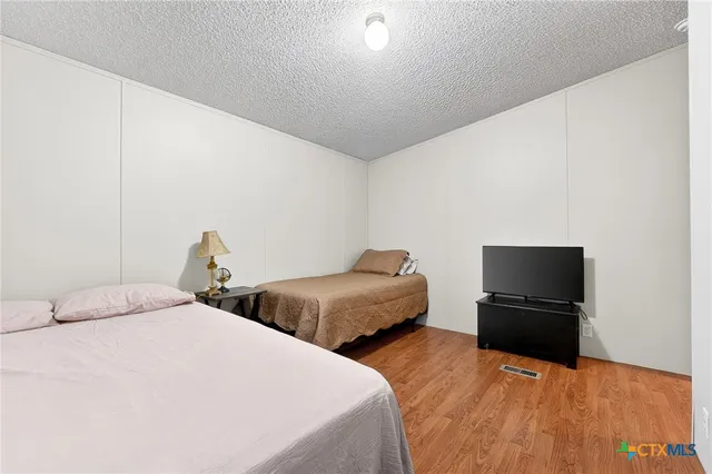 a bedroom with two bed and a television