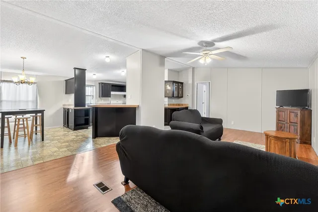 a living room with furniture and a kitchen view