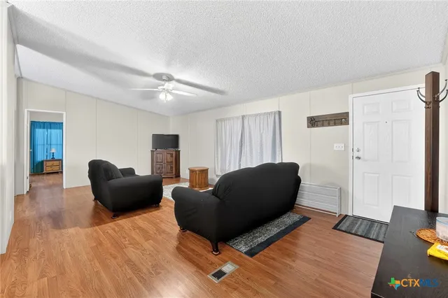 a living room with furniture and a wooden floor