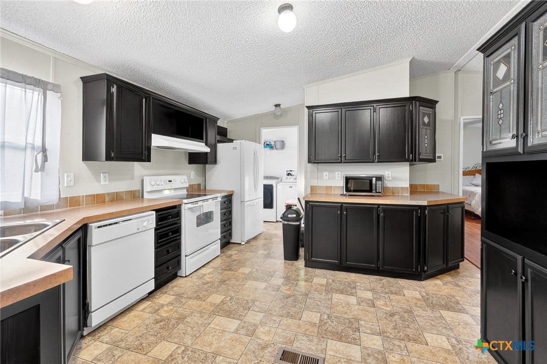 11213 Ridgewood Drive Salado, TX 76571 - Photo 8 of 24 a kitchen with a refrigerator and a stove top oven