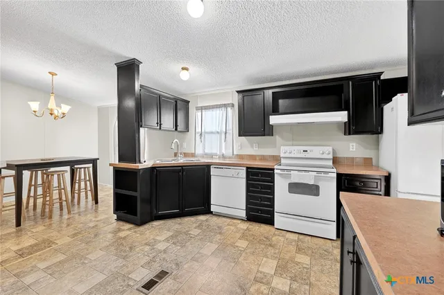 a kitchen with a stove sink and a refrigerator