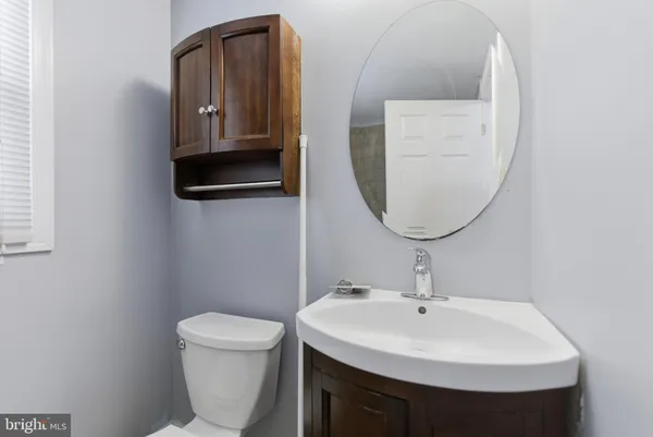 a bathroom with a toilet a sink and a mirror