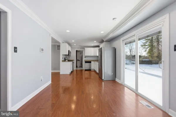 a view of a kitchen with wooden floor and a window