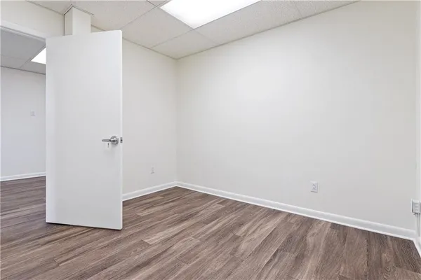 an empty room with wooden floor and white wall
