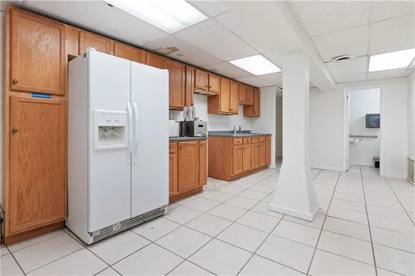 a large white kitchen with stainless steel appliances granite countertop a refrigerator and a sink