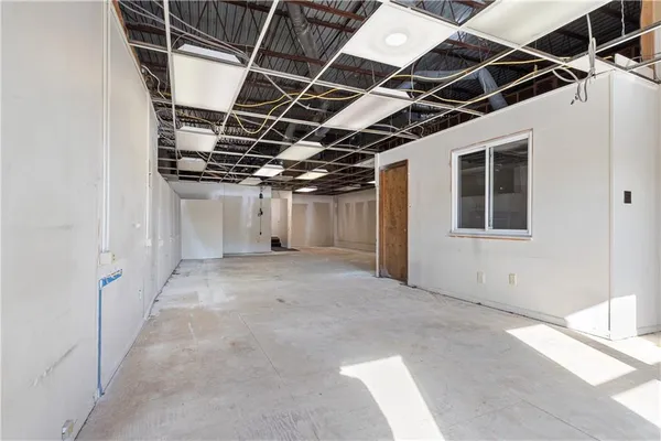 a view of an empty room with wooden floor and windows
