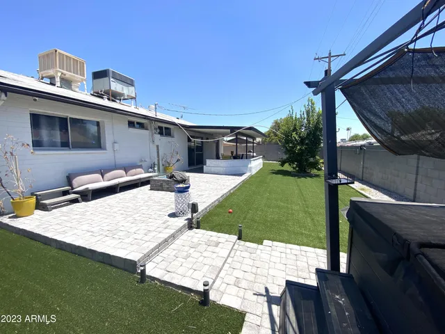 a view of a patio with table and chairs under an umbrella