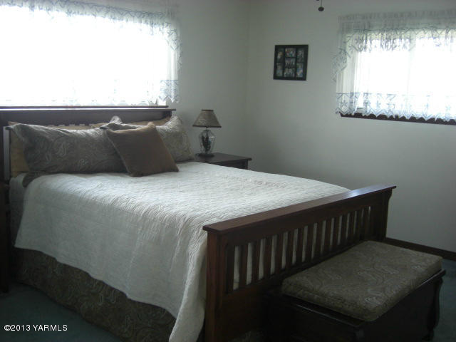 13907 Fisk Road Yakima, WA 98908 - Photo 19 of 55 a bed sitting in a bedroom next to a window