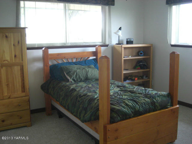 13907 Fisk Road Yakima, WA 98908 - Photo 26 of 55 a living room with a bed and a dresser