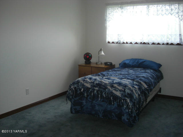 13907 Fisk Road Yakima, WA 98908 - Photo 27 of 55 a bed sitting in a bedroom next to a window