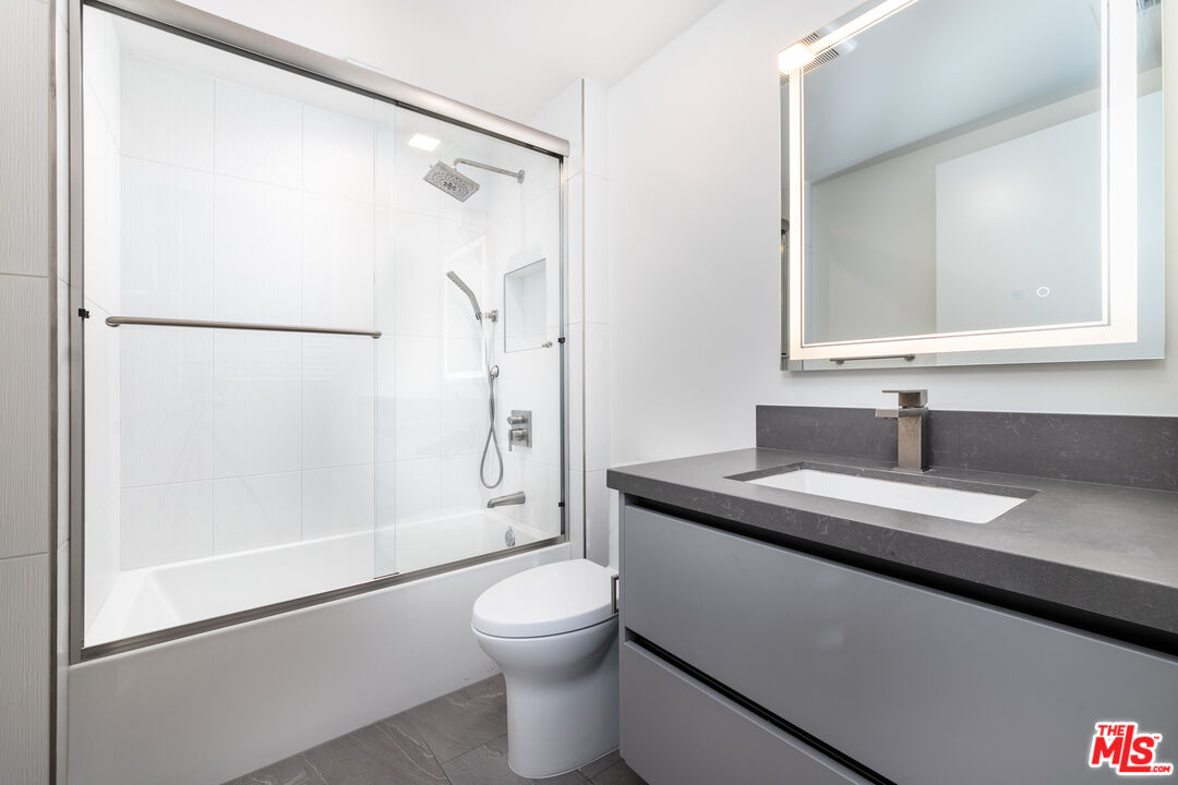 1951 Manning Avenue Los Angeles, CA 90025 - Photo 12 of 27 a bathroom with a granite countertop sink toilet and shower