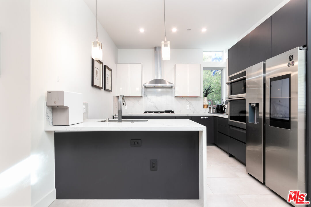 1951 Manning Avenue Los Angeles, CA 90025 - Photo 3 of 27 a kitchen with stainless steel appliances a sink stove and refrigerator