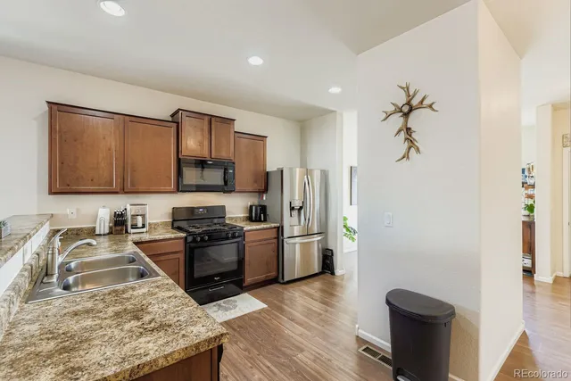 a kitchen with stainless steel appliances granite countertop a sink stove and refrigerator