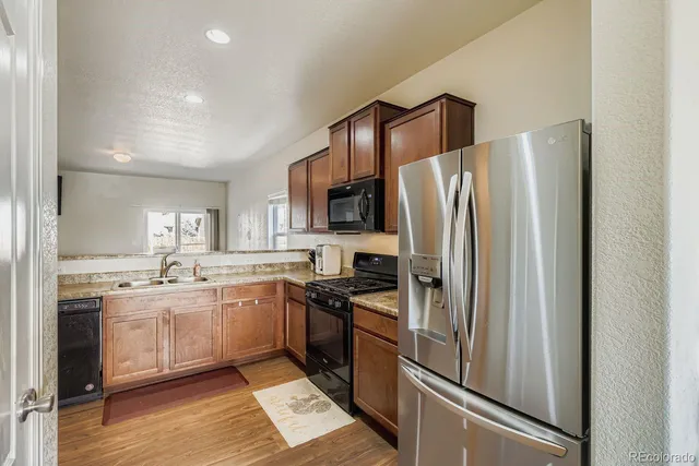a kitchen with stainless steel appliances granite countertop a refrigerator and a sink