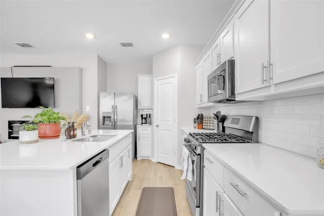 a kitchen with stainless steel appliances granite countertop a sink stove and refrigerator