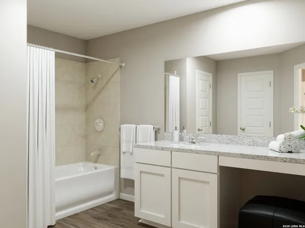a bathroom with a granite countertop sink mirror and a bathtub