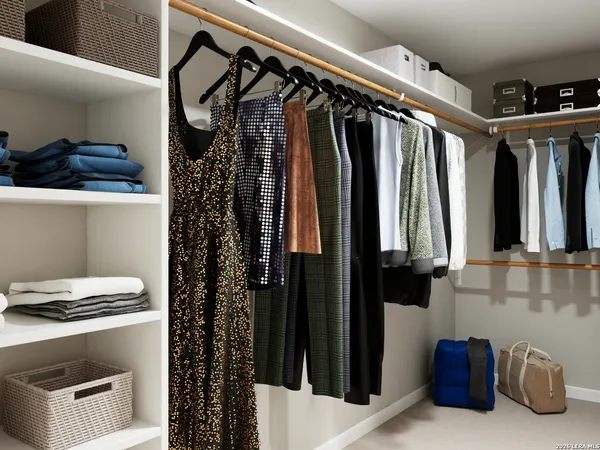 a view of walk in closet with clothes and shoes