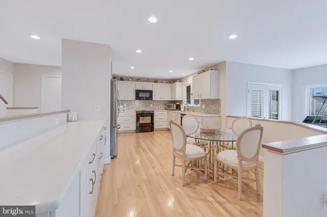 a living room with furniture and a dining table with kitchen view