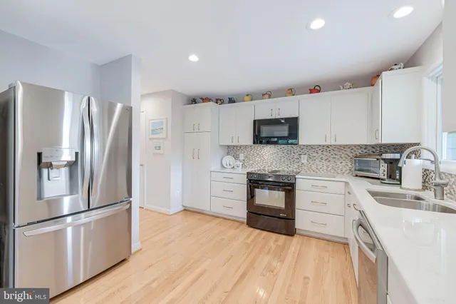 a kitchen with stainless steel appliances a refrigerator sink and microwave