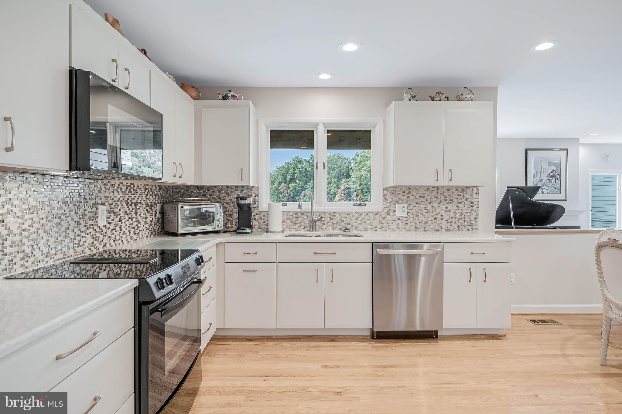 1933 Lakeport Way Reston, VA 20191 - Photo 18 of 57 a kitchen with stainless steel appliances granite countertop a stove and white cabinets