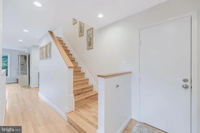 a view of a hallway with wooden floor and stairs