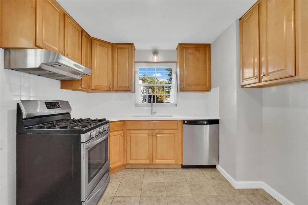 138 Abbott Street Springfield, MA 01118 - Photo 11 of 41 a kitchen with stainless steel appliances granite countertop a stove a sink and a refrigerator