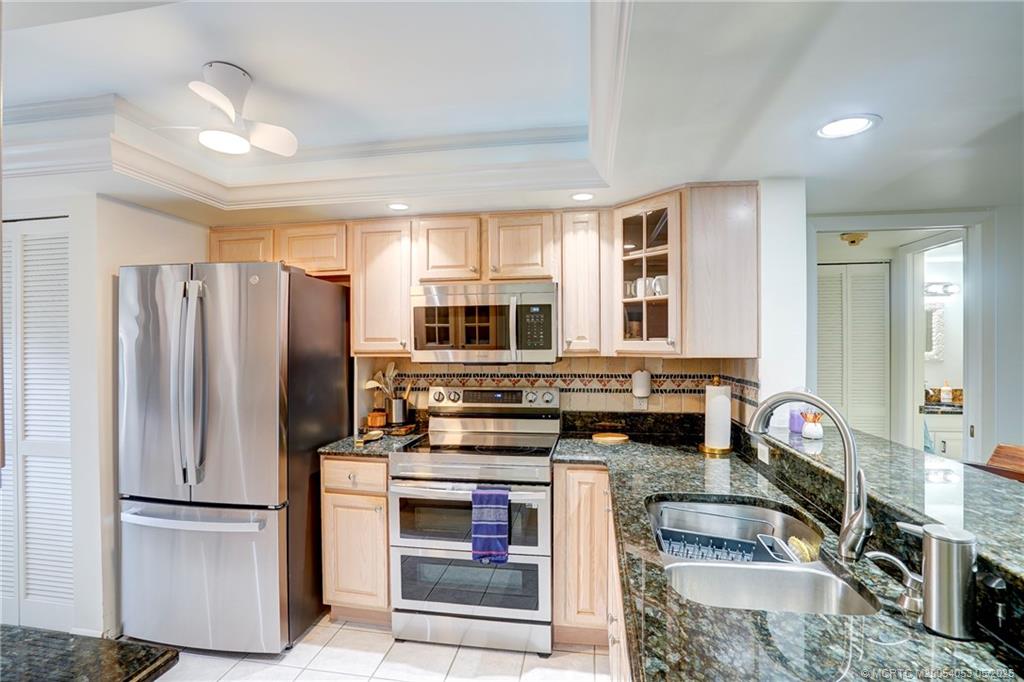 10 Northeast Plantation Road, Unit 101 Jensen Beach, FL 34957 - Photo 30 of 53 a kitchen with stainless steel appliances granite countertop a refrigerator stove and sink