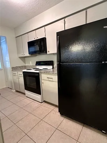 a kitchen with stainless steel appliances wooden cabinets a stove a microwave and a refrigerator