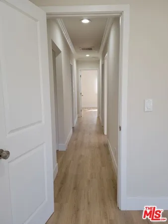 a view of a hallway with wooden floor