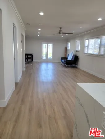 a view of empty room with wooden floor and windows