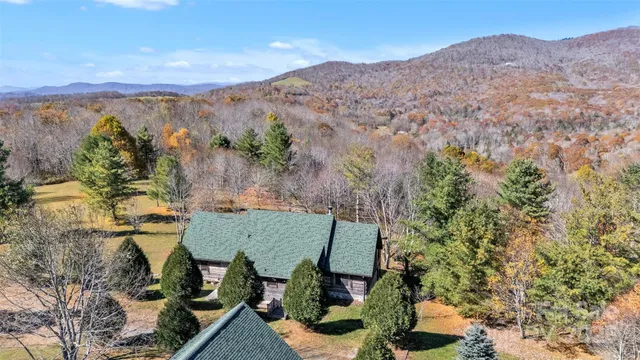 an aerial view of a house with a mountain