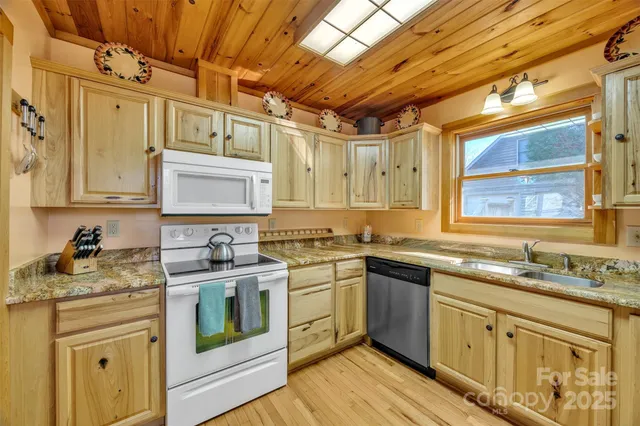a kitchen with stainless steel appliances granite countertop a sink stove cabinets and wooden floor