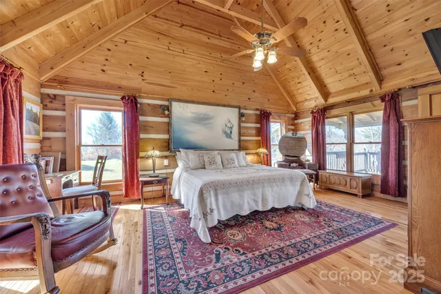 a bedroom with a bed a couch and large windows