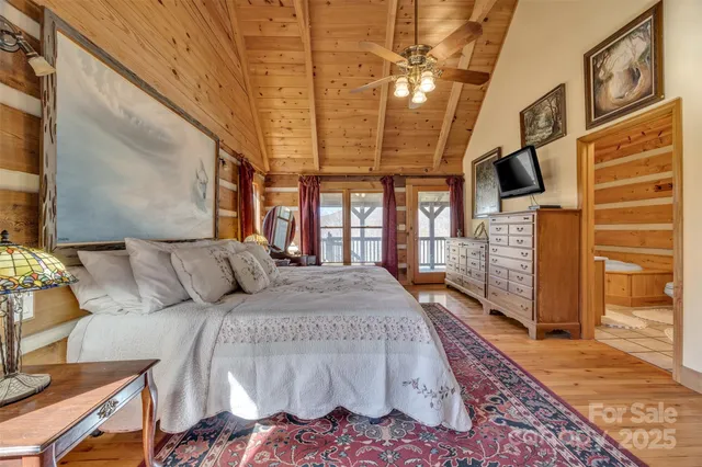 a large bedroom with a bed and wooden floor