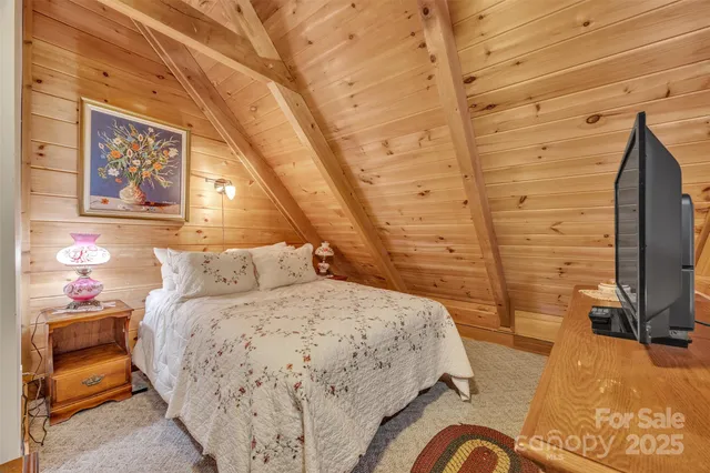 a bedroom with a bed and flat screen tv