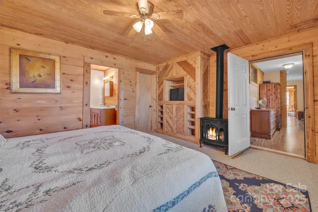 a spacious bedroom with a bed dresser and a flat tv screen